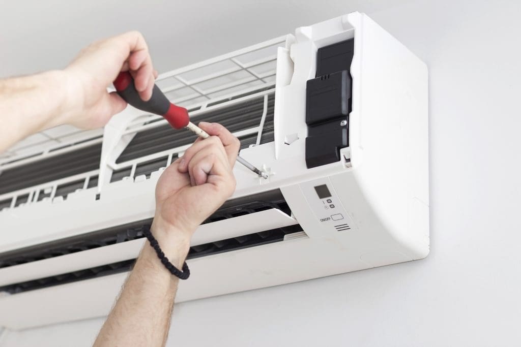 Young man installing air conditioner in an apartment